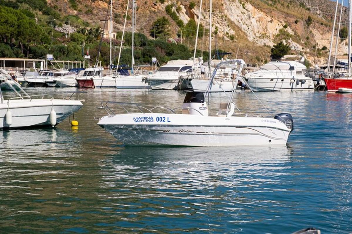 a white boat sitting in the water with other boats