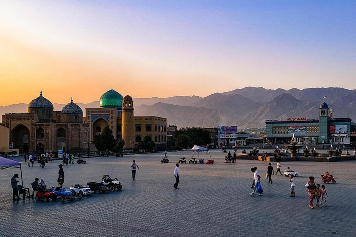 a group of people in a square in front of a mosque