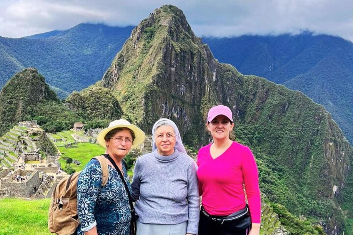 três mulheres em pé em frente a uma montanha