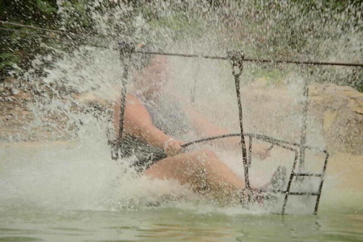 isang lalaking nakaupo sa isang swing sa tubig
