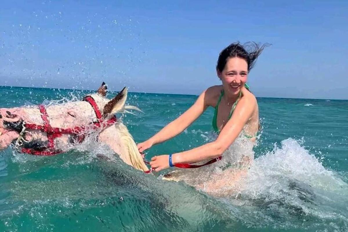 uma mulher cavalgando um cavalo no oceano