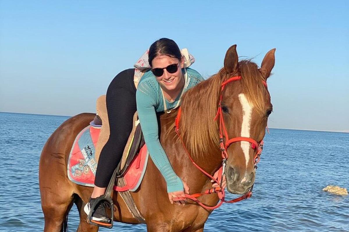 seorang wanita menunggang kuda di pantai