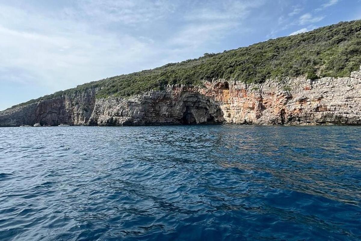 un grande specchio d'acqua accanto a una montagna rocciosa