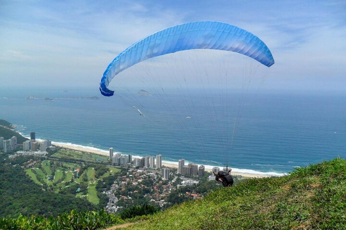 una persona volando en paracaídas en la cima de una colina