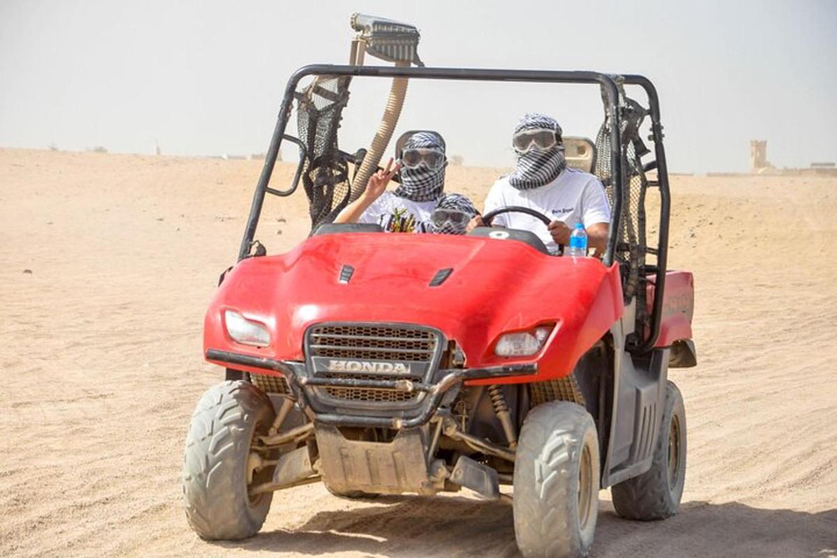 dois homens andando em um quadriciclo no deserto