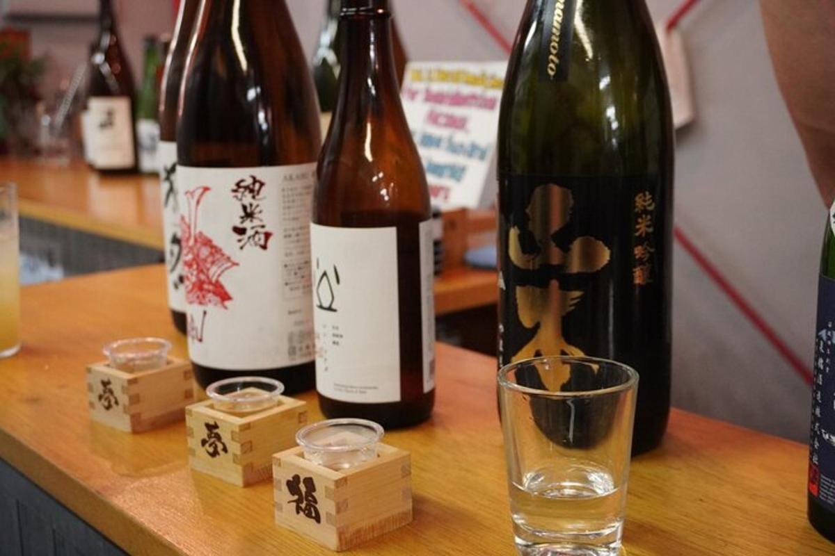 Tres botellas de vino sobre una mesa con una copa.