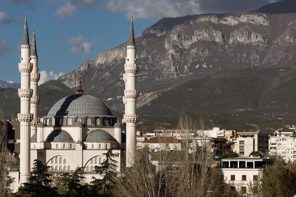 ένα τζαμί με δύο τρούλους μπροστά σε ένα βουνό
