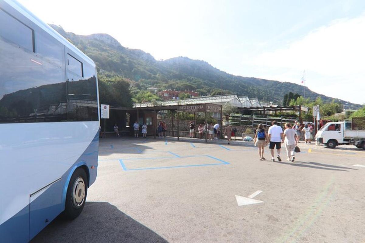 skupina lidí jdoucích po parkovišti vedle autobusu