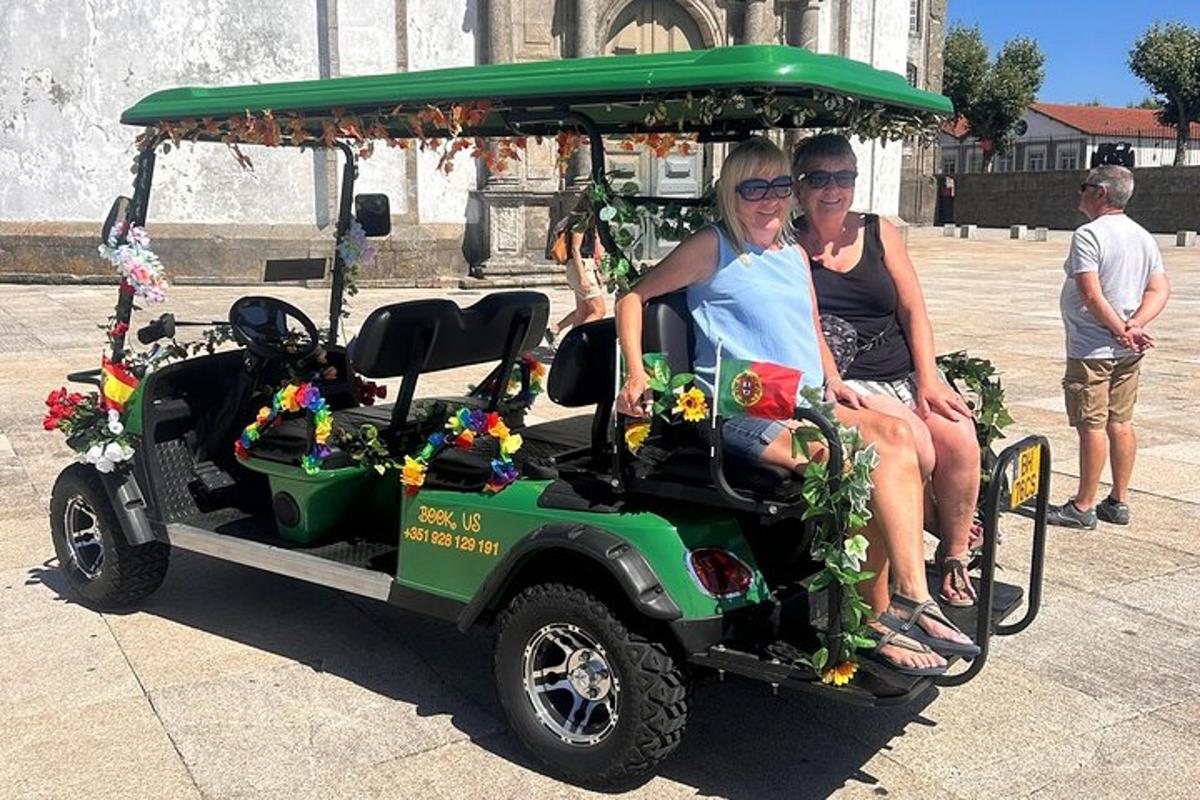 dva lidé sedí na golfovém vozíku