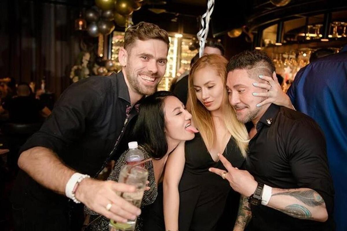 skupina lidí pózujících pro fotografii na večírku
