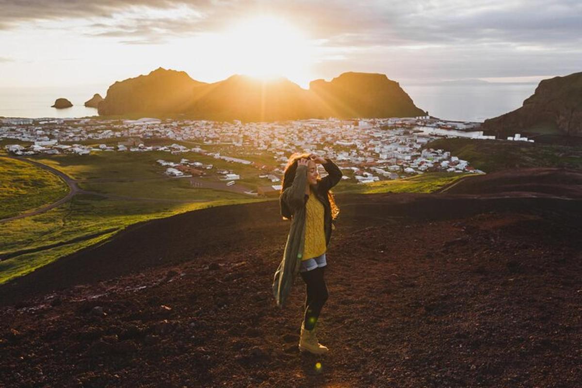 a woman standing on a hill looking at the sunset