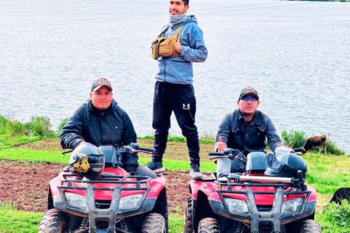 tres homes estan drets al costat de l'aigua amb quads