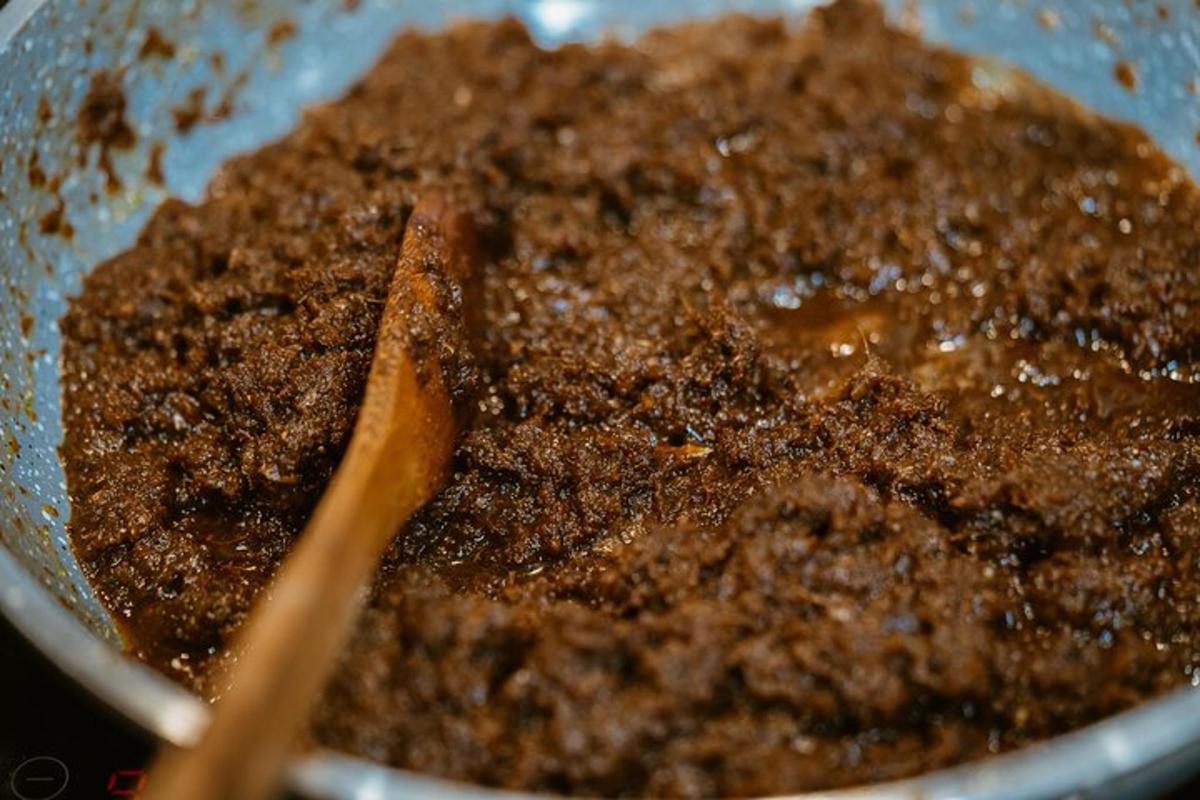 a bowl filled with brown dirt with a pair of chopsticks