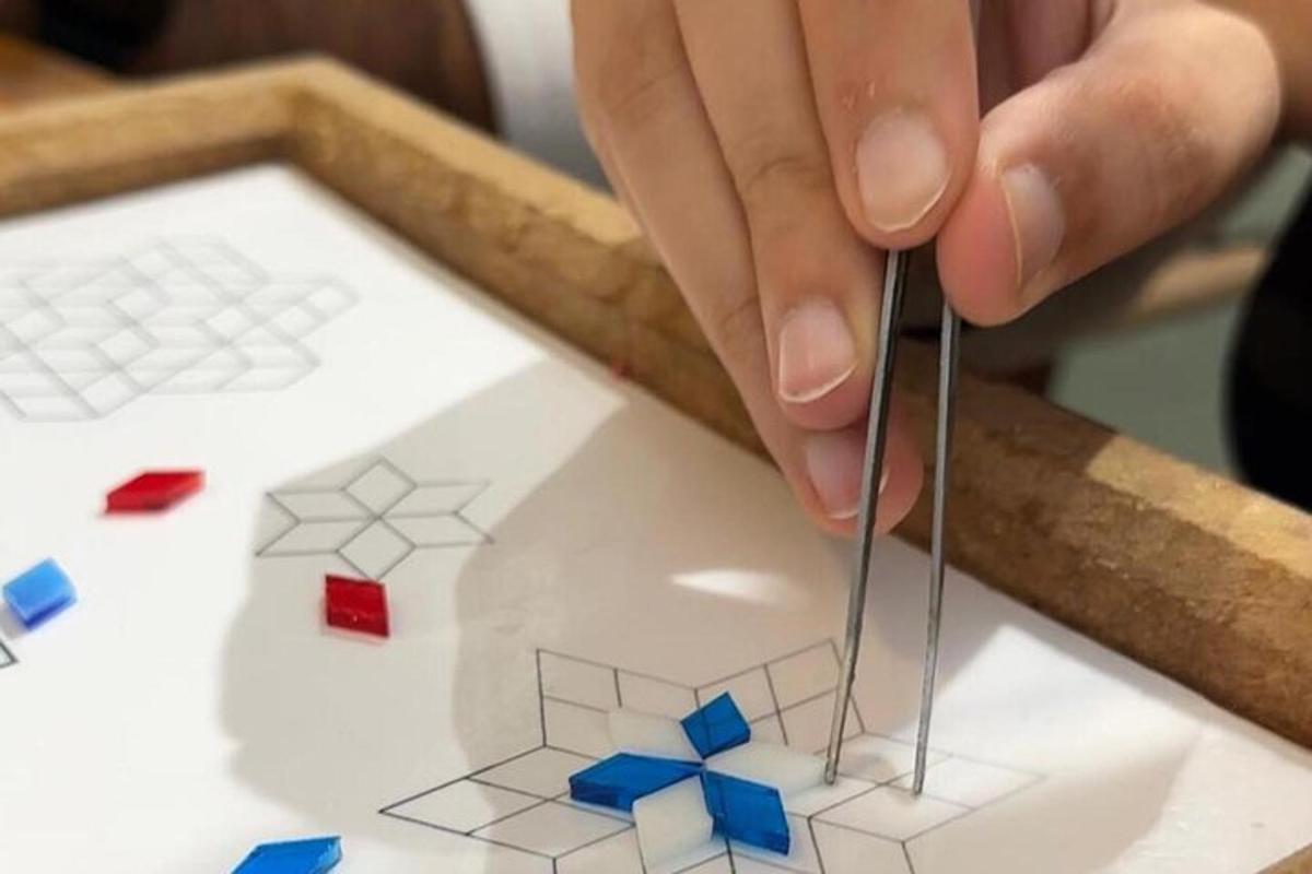 egy személy ollóval kivág egy házmodellt