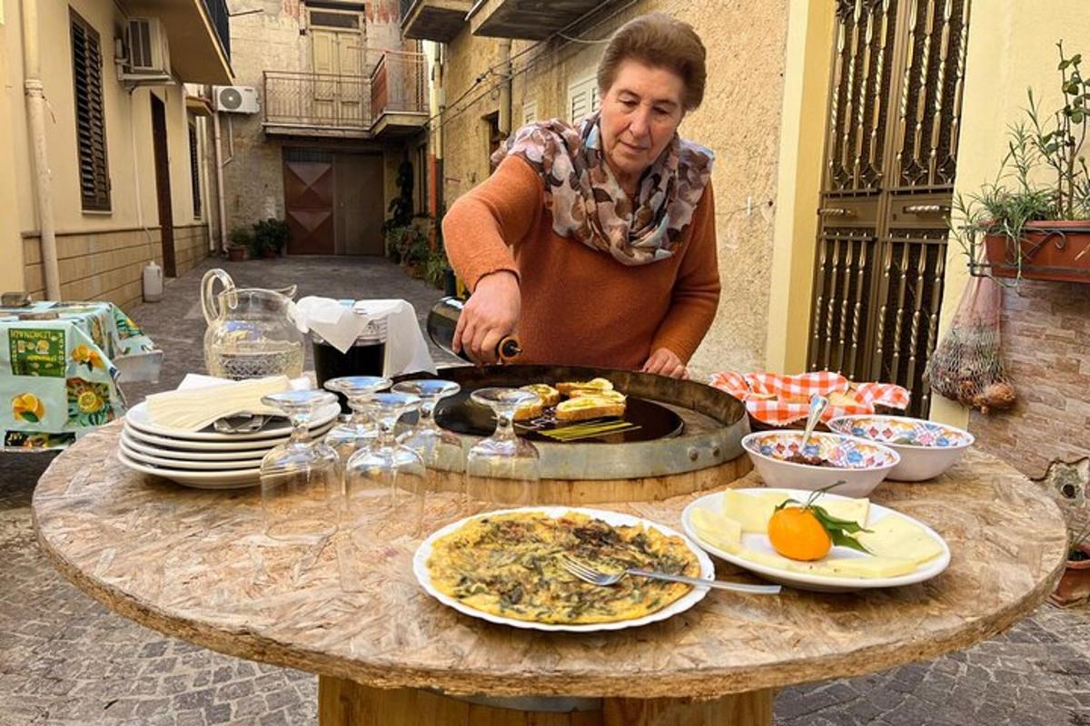 žena stojící před stolem s jídlem