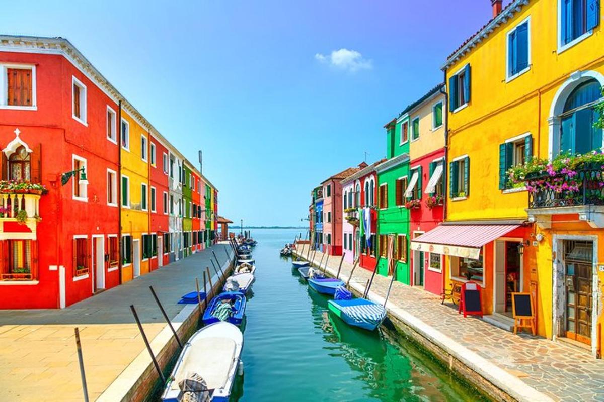 a row of boats in a canal with colorful buildings