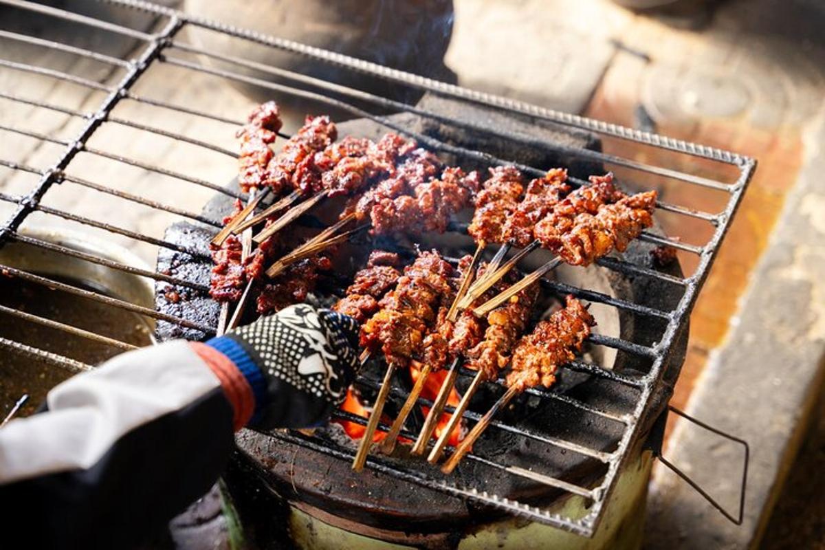 člověk vaří jídlo na grilu