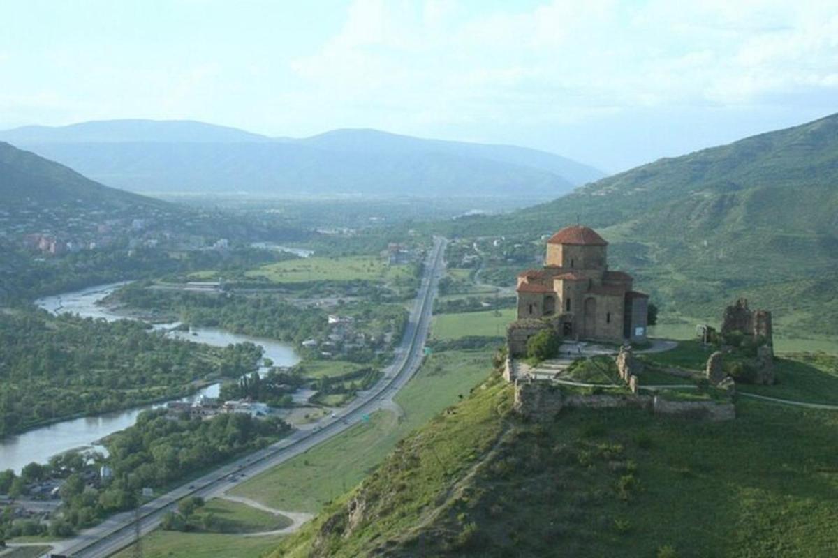 an old building on a hill next to a river