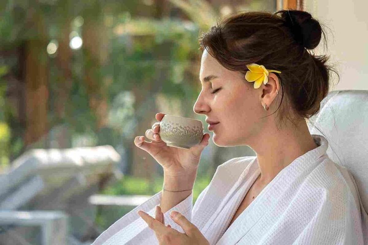 a woman in a bathrobe holding a cup of coffee