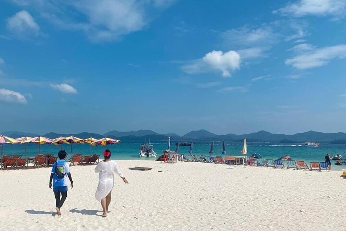 zwei Frauen gehen an einem Strand mit Blick auf das Meer spazieren