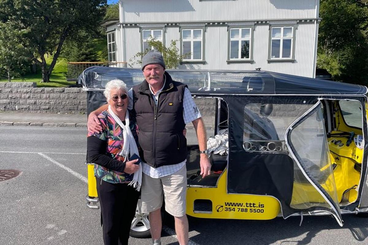 muž a žena stojící vedle golfového vozíku