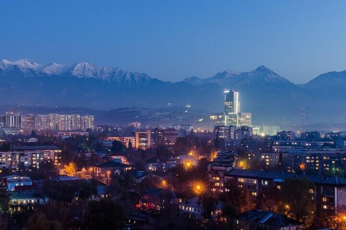 нічне місто з горами на задньому плані