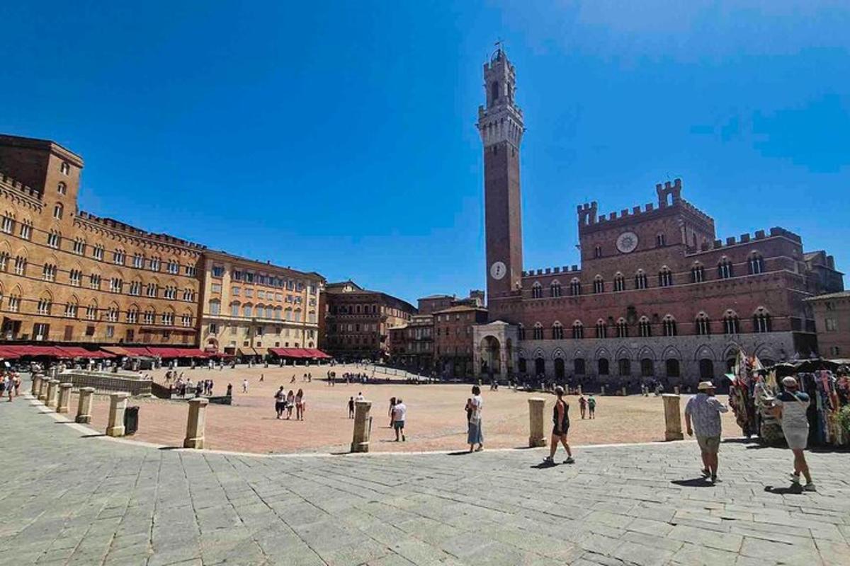 a group of people walking around a city square with a clock tower