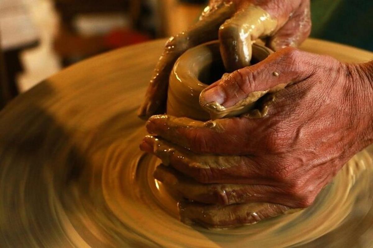 un paio di mani che modellano un vaso su un tornio da vasaio