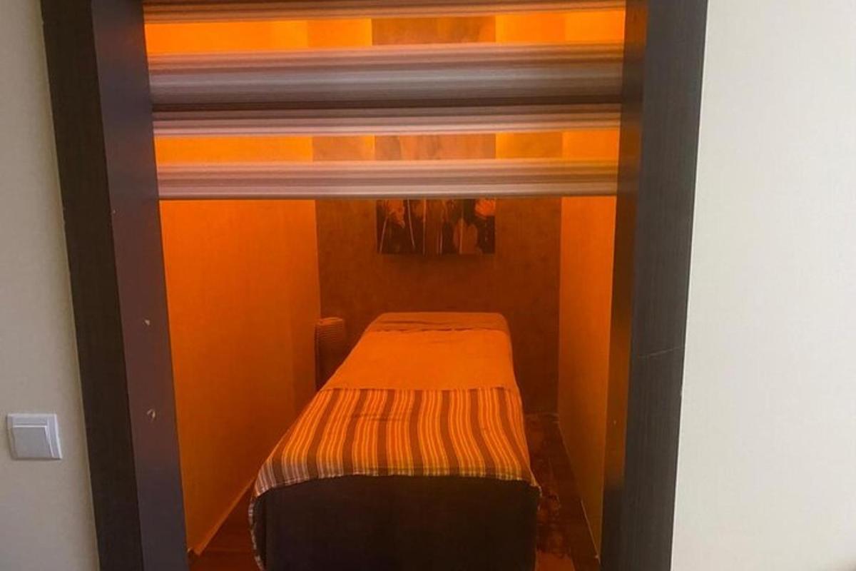 malá postel v malém pokoji s oranžovými stěnami