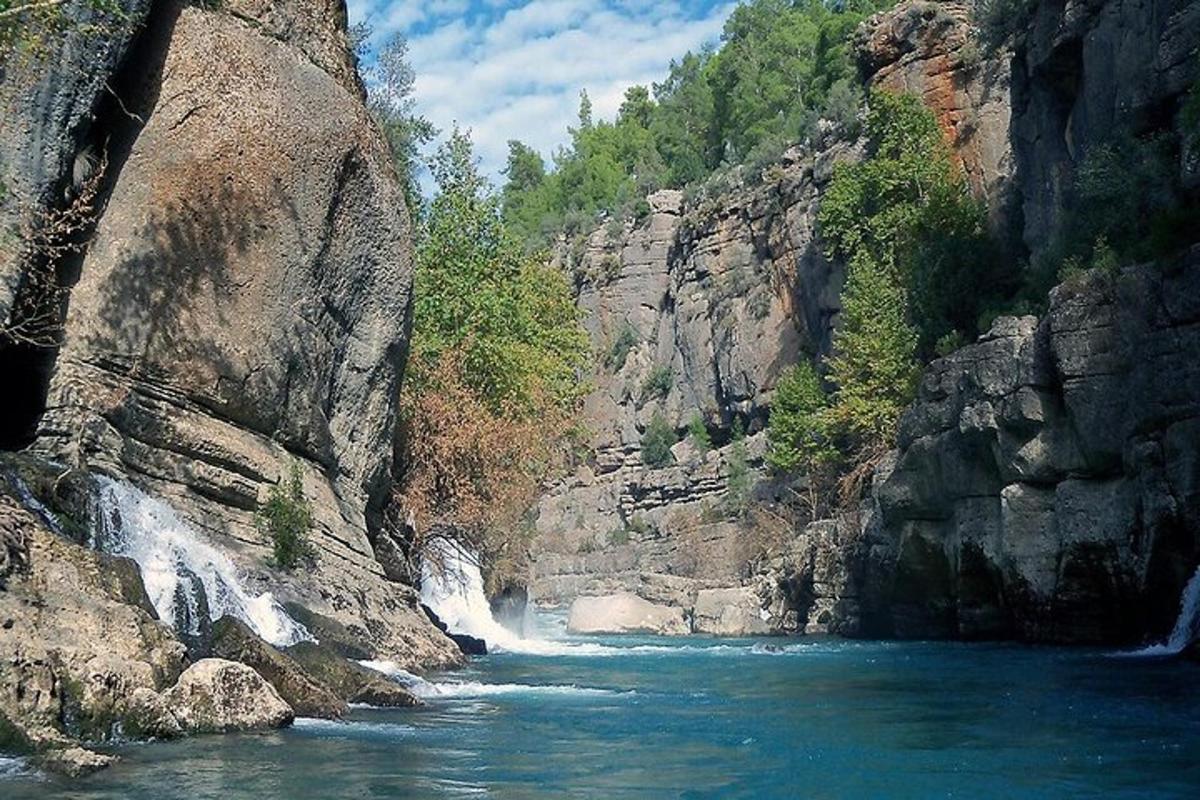 rijeka koja teče kroz stjenovitu planinu s vodopadom