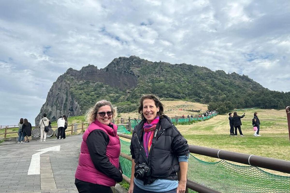 two women posing for a picture in front of a mountain