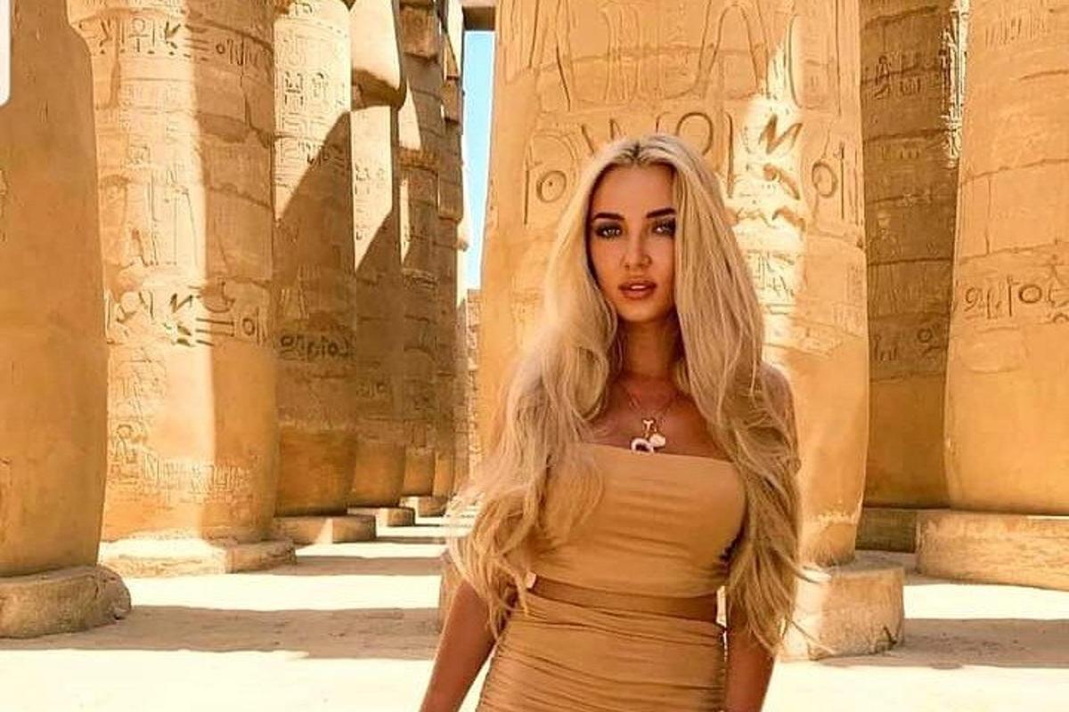 una donna in abito in piedi davanti alle rovine