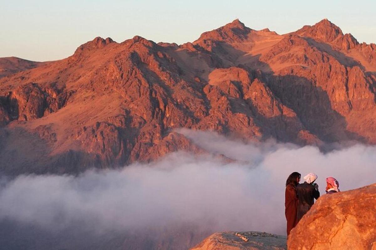 dua orang berdiri di puncak gunung
