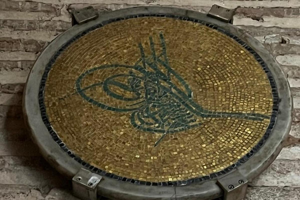 plat logam dengan burung di atasnya di dinding bata