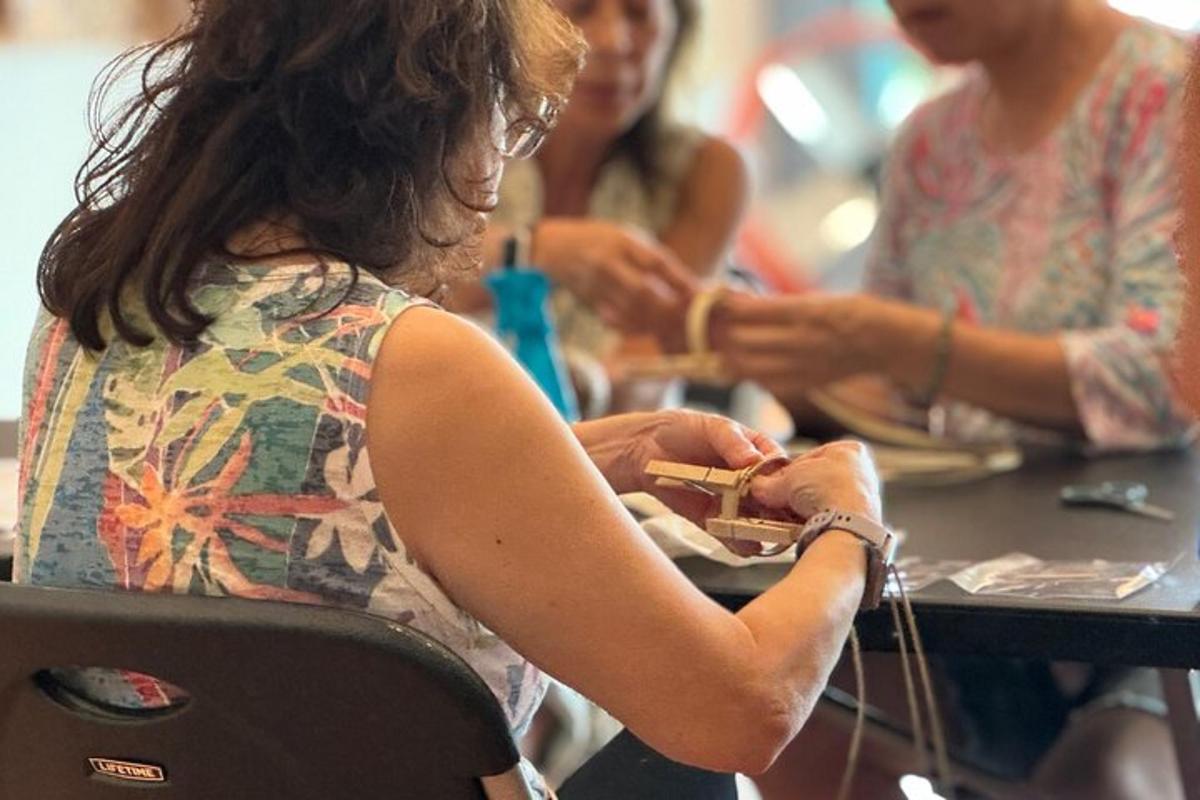 naine istub laua taga ja vaatab oma mobiiltelefoni