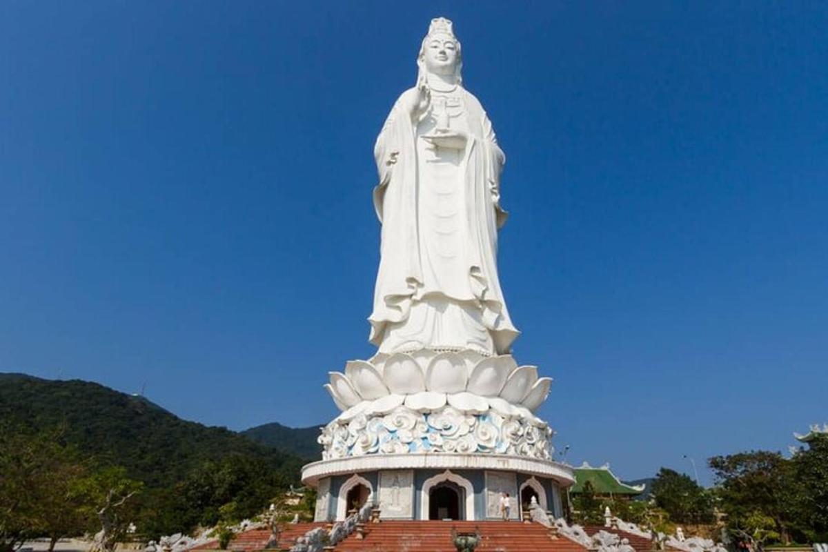 uma grande estátua branca no topo de um edifício