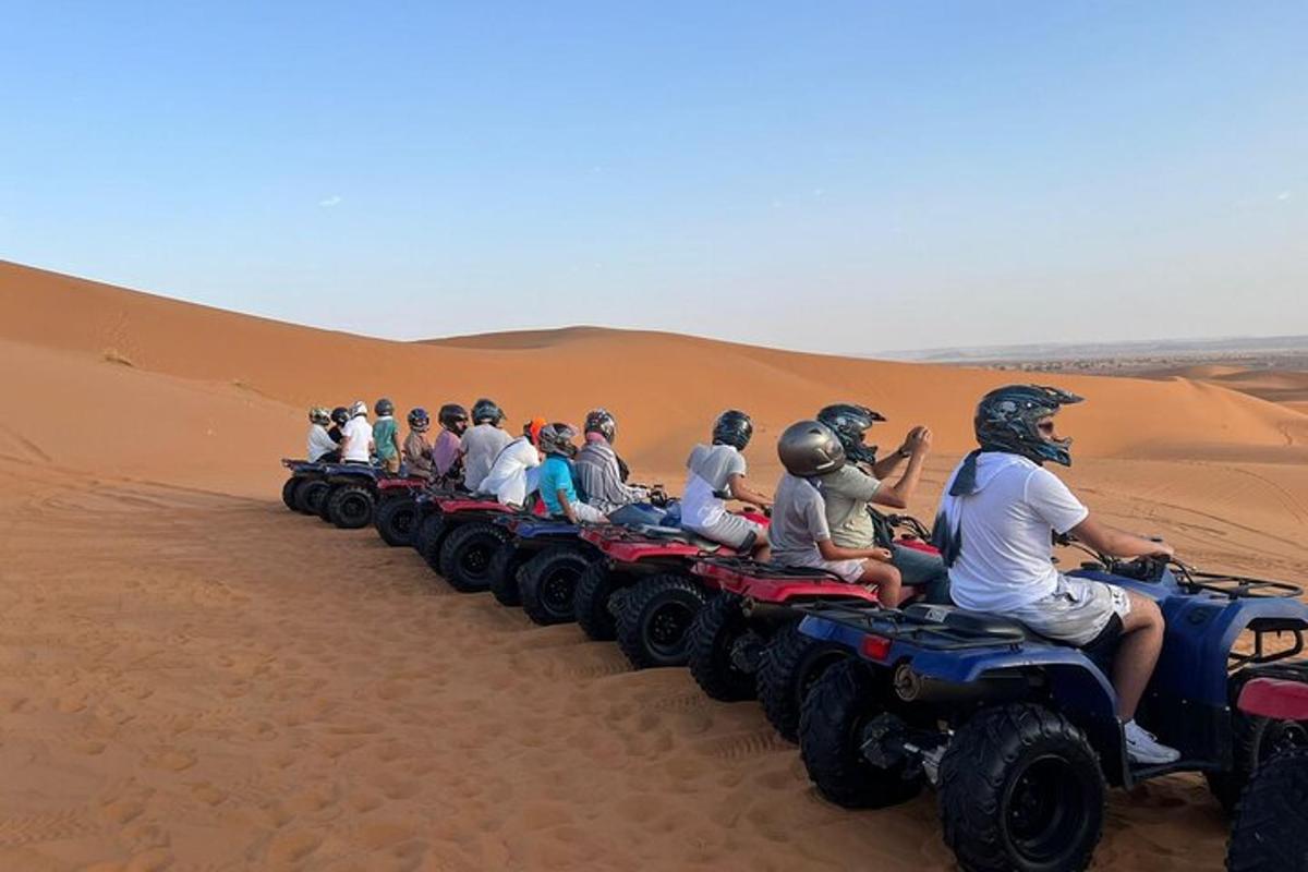 um grupo de pessoas andando de quadriciclo no deserto