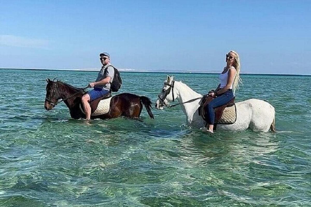 un uomo e una donna a cavallo nell'oceano