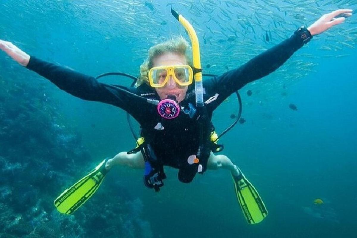 un uomo con muta e occhialini che nuota nell'acqua