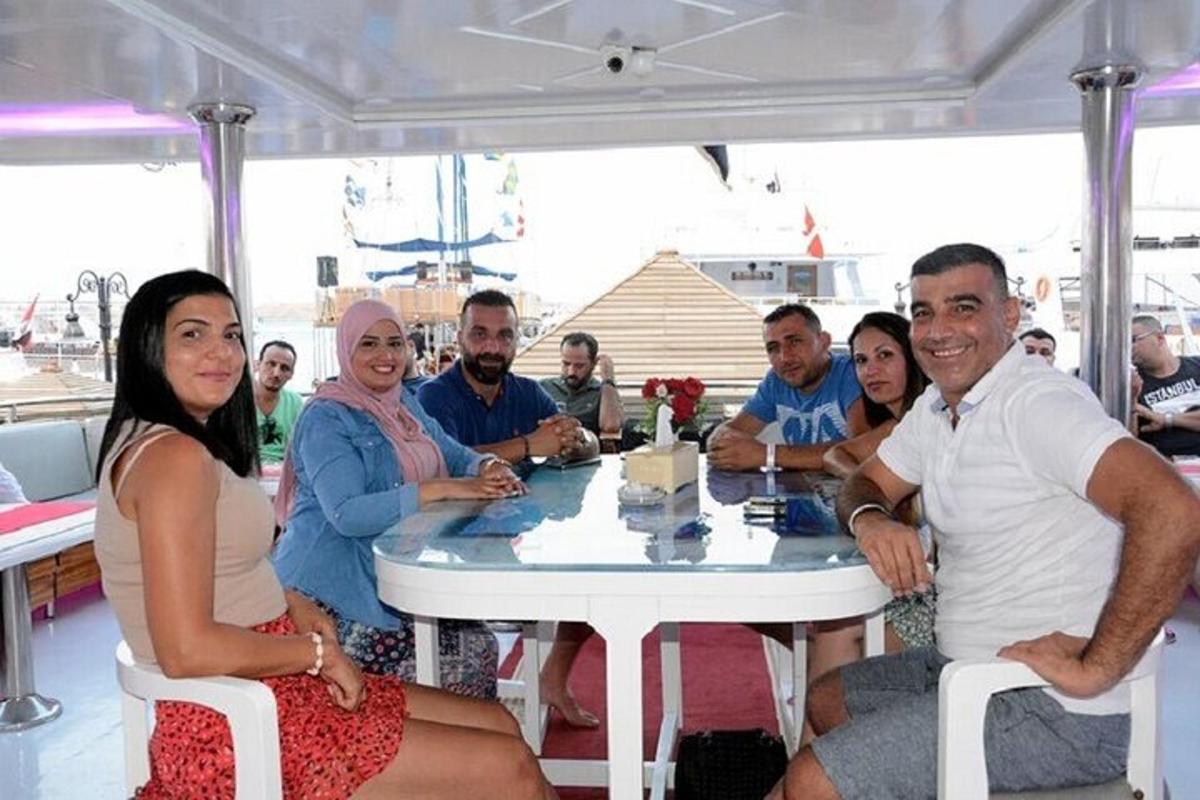 a group of people sitting around a table on a boat
