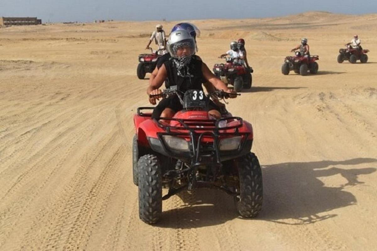 un gruppo di persone in sella a quad nel deserto