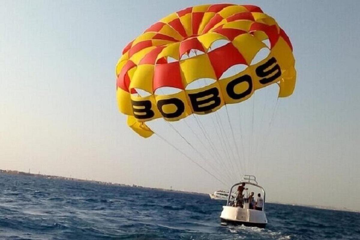 a yellow and red parachute flying over the ocean