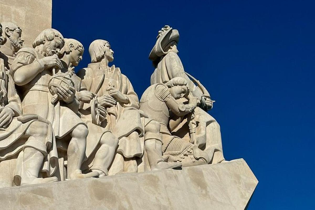 en statue af mennesker på siden af en bygning