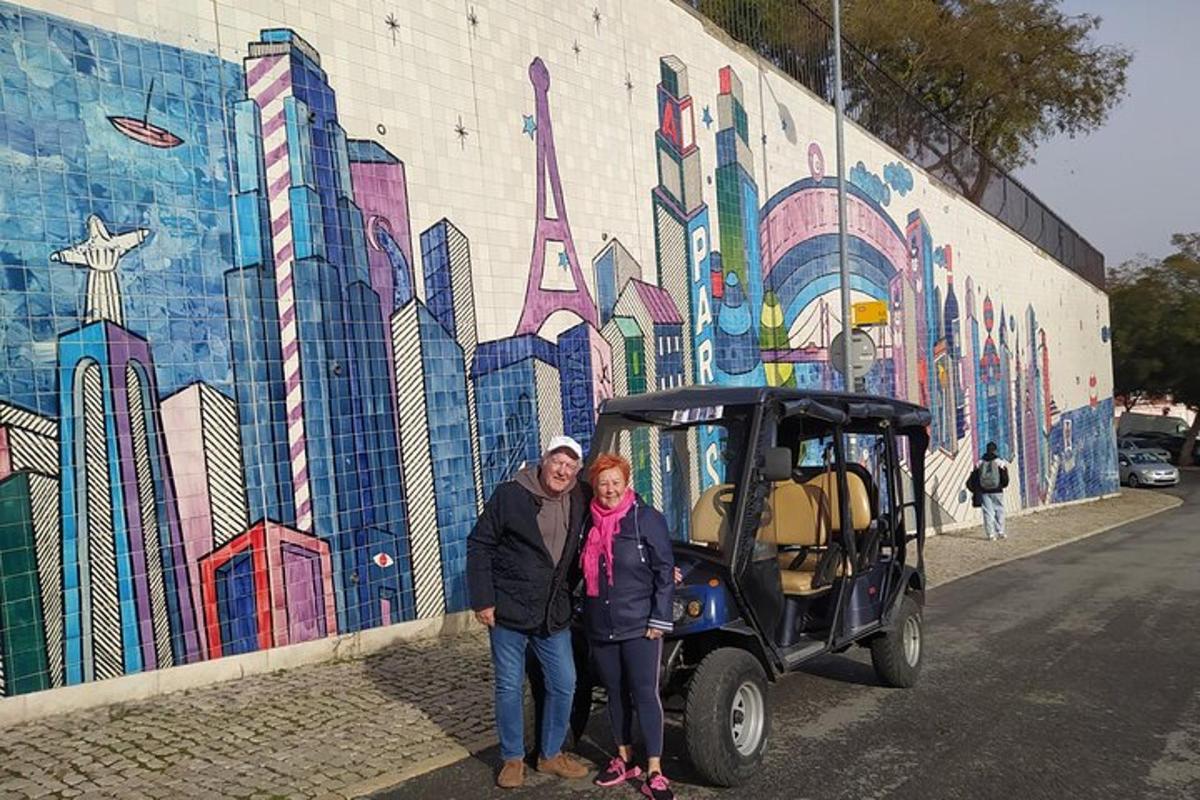 um homem e uma mulher em pé em frente a um mural