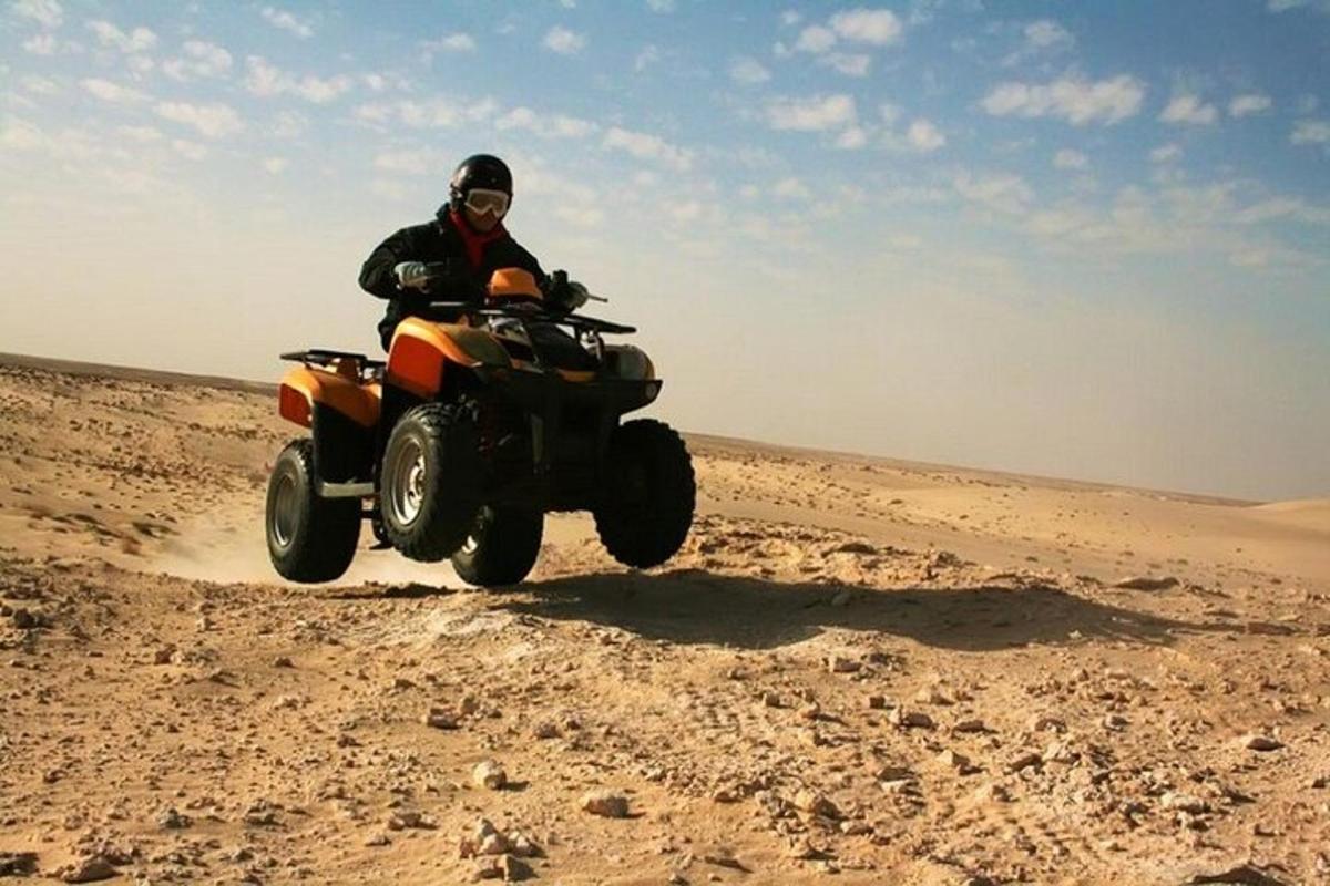 una persona conduciendo un quad en el desierto