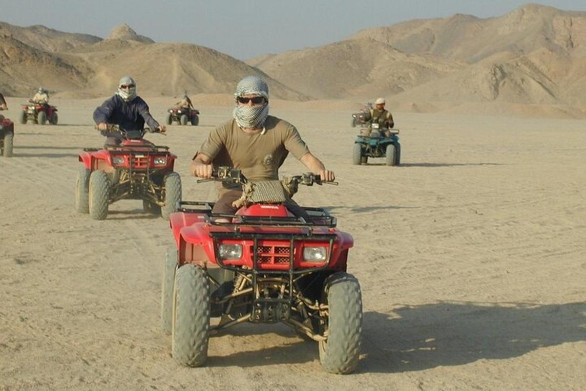 Un hombre en un vehículo de cuatro ruedas en el desierto