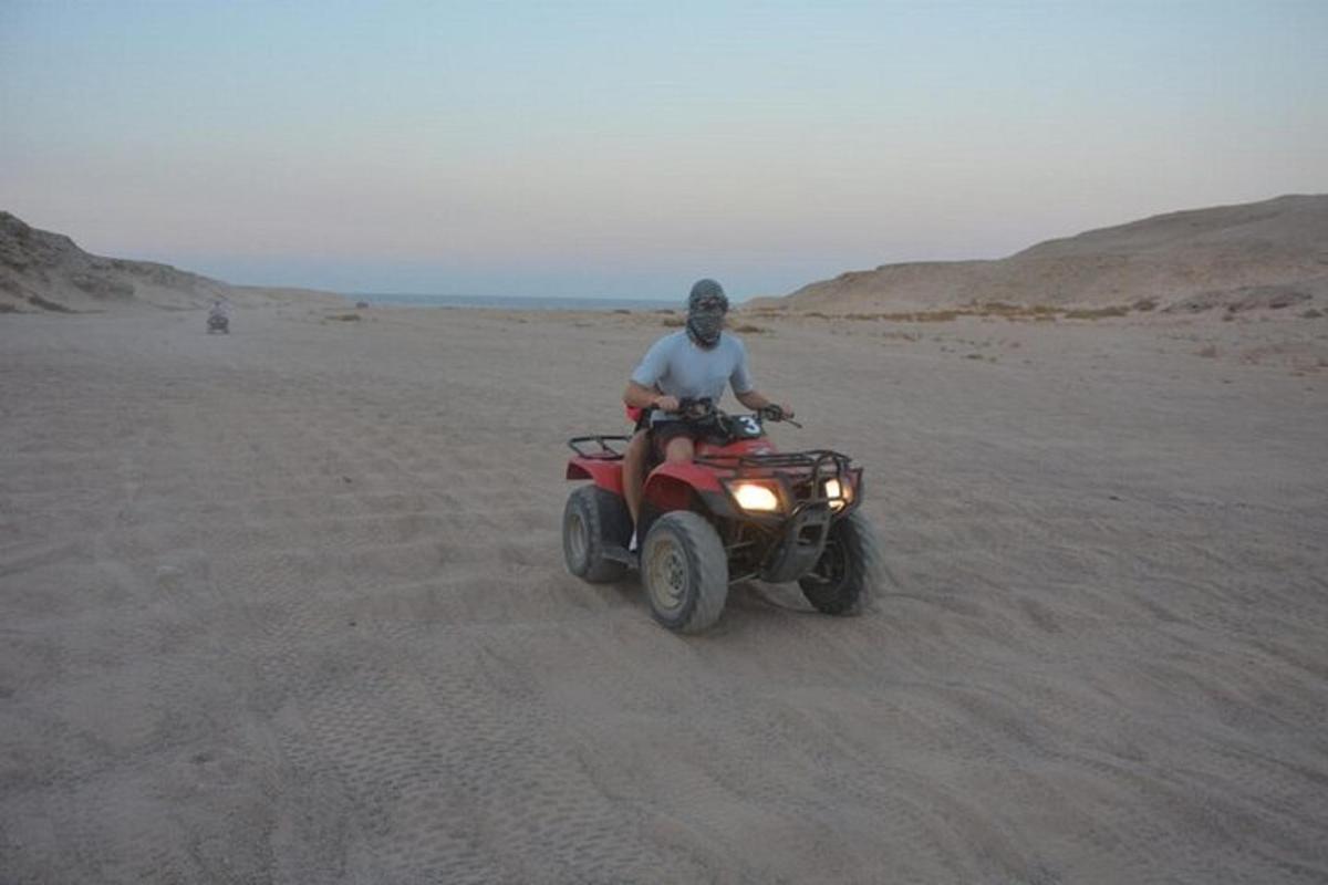 Un hombre conduciendo un quad en el desierto