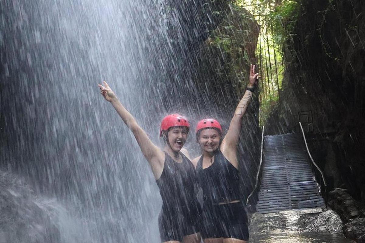 due persone sono in piedi sotto la pioggia davanti a una cascata