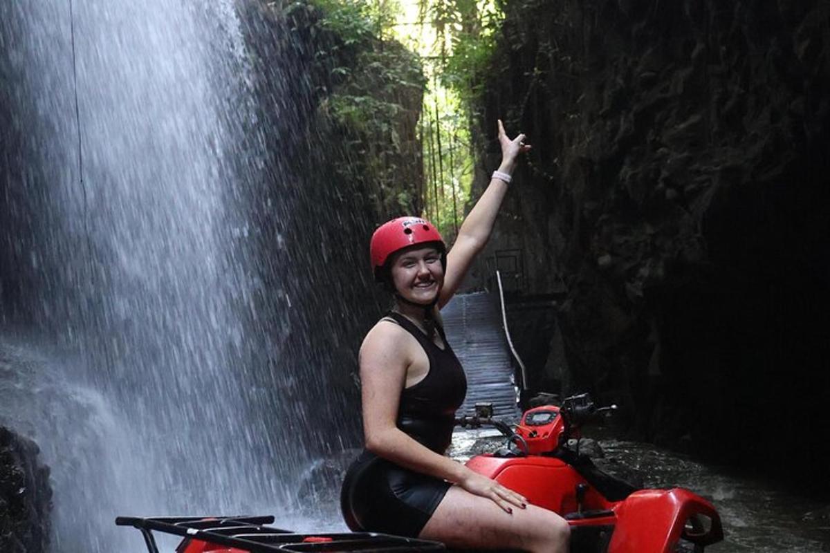 žena jedoucí na motorce před vodopádem