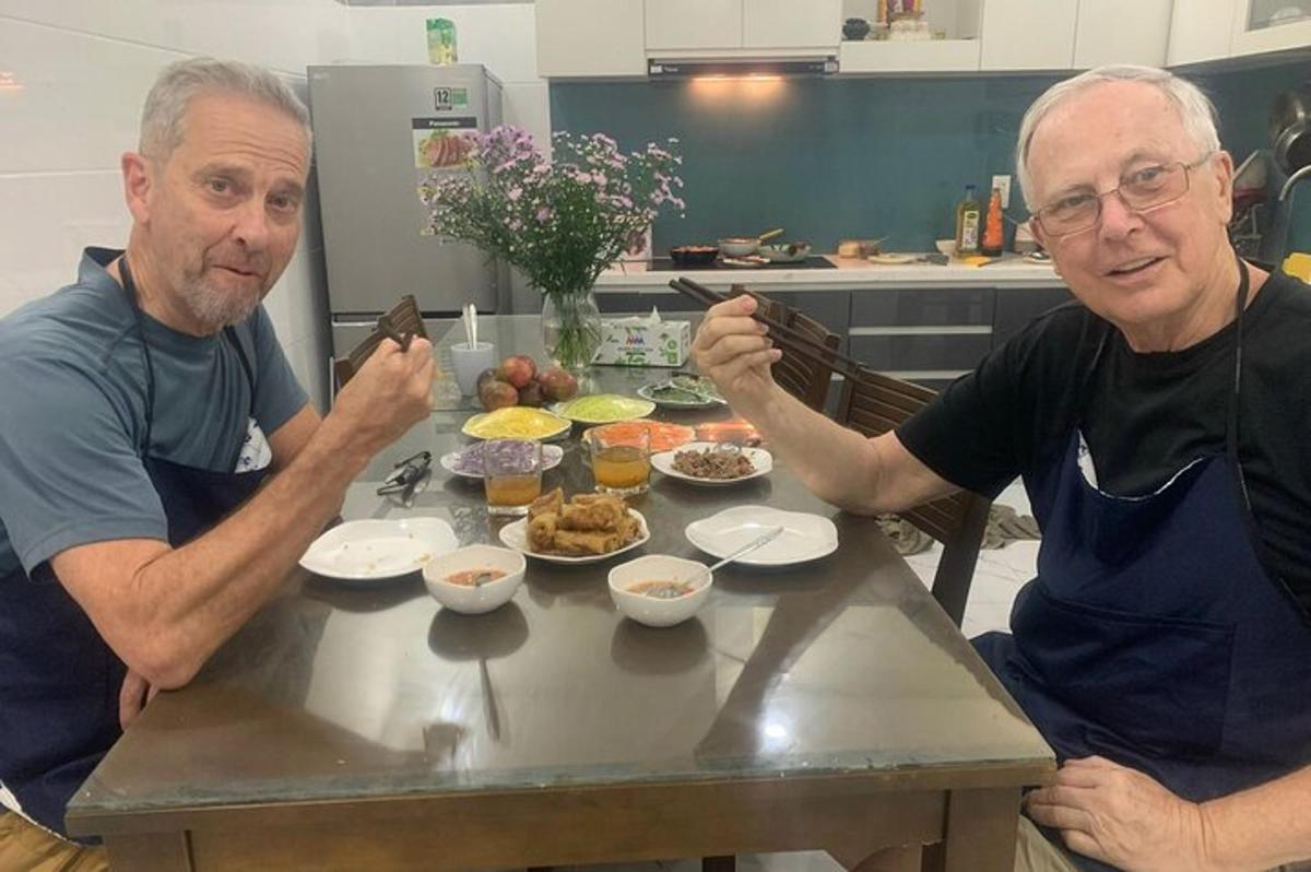 dois homens sentados à mesa com pratos de comida